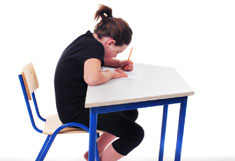 Child bent over a school desk