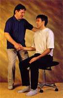Teacher helping student to detect and release muscular tension while sitting. This results in a more relaxed and upright posture.