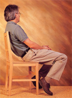 Man leaning back in a chair. This type of misuse of the body can cause severe back pain over time.
