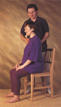 Alexander Technique teacher helping a pregnant woman with her posture while sitting