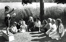 Children gathered round a child on a soapbox