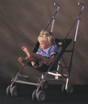 Young child struggling to get comfortable in a typical backward sloping pushchair