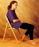 The backward-sloping chair causes poor posture for this girl