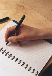 Relaxed hand writing on pad of paper